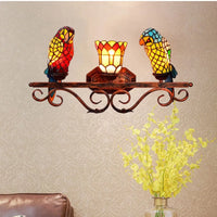 Design-Wandleuchte aus farbigem Glas mit Papageienmotiv