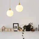 Minimalistische Pendelleuchte aus Messing mit milchglas Orbe
