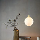 Minimalistische Pendelleuchte aus Messing mit milchglas Orbe