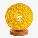 LED-Tischlampe mit Holzsockel und Stoffkugel in Weidenoptik