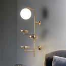 Applique murale design LED avec plusieurs disques dorés et boule en verre