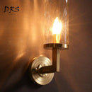 Goldene Wandleuchte mit zylindrischem Glasschirm